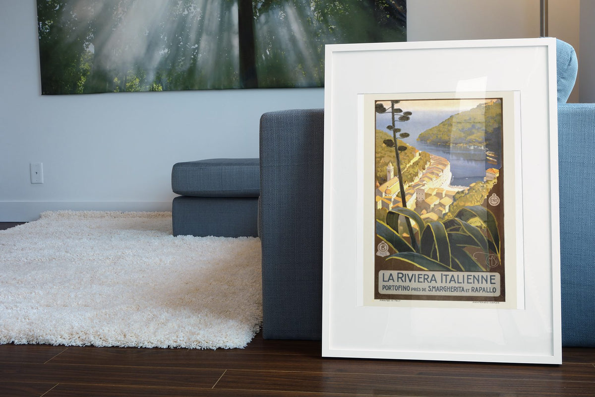 La Riviera Italienne Portofino poster leaning beside a blue sofa
