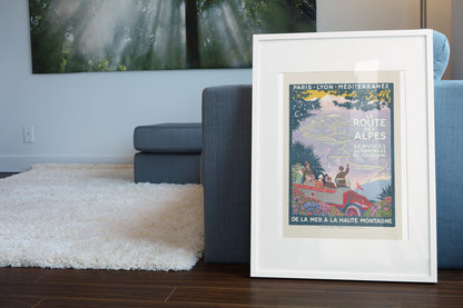 La Route des Alpes poster leaning beside a blue sofa