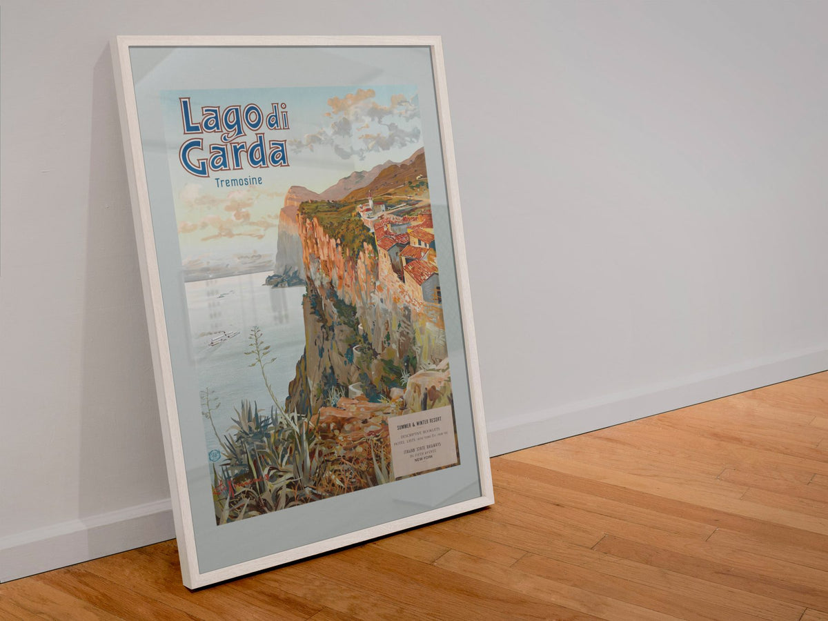 Lago di Garda poster in a white frame leaning against a wall