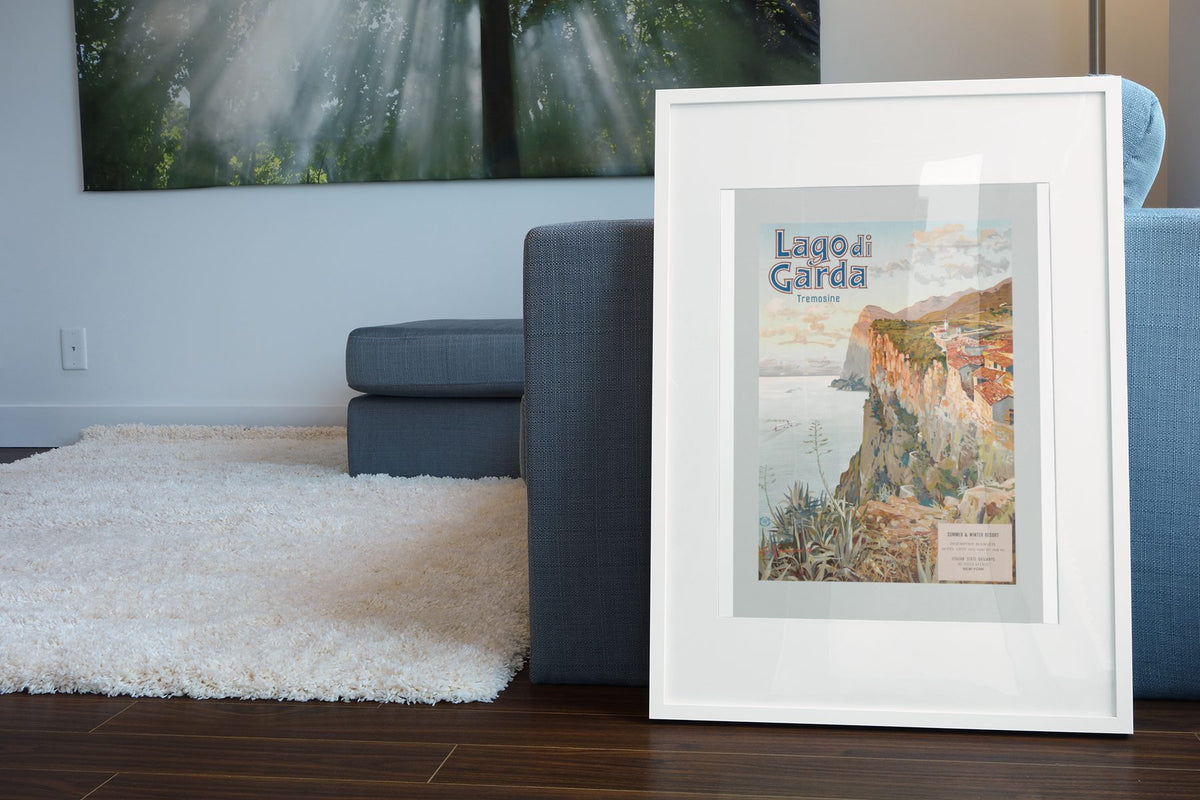 Lago di Garda poster leaning beside a blue sofa