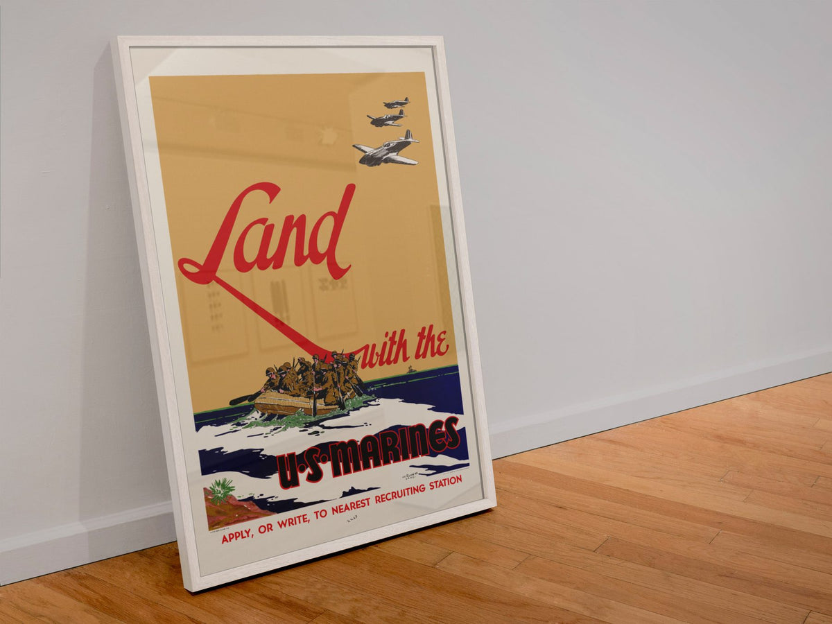 Land with the U.S. Marines poster in a white frame leaning against a wall