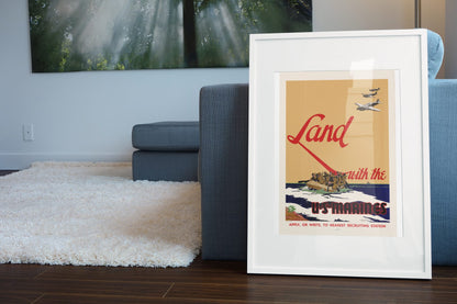 Land with the U.S. Marines poster leaning beside a blue sofa