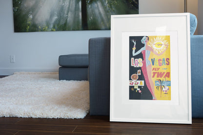 Las Vegas Fly TWA Showgirl poster leaning beside a blue sofa