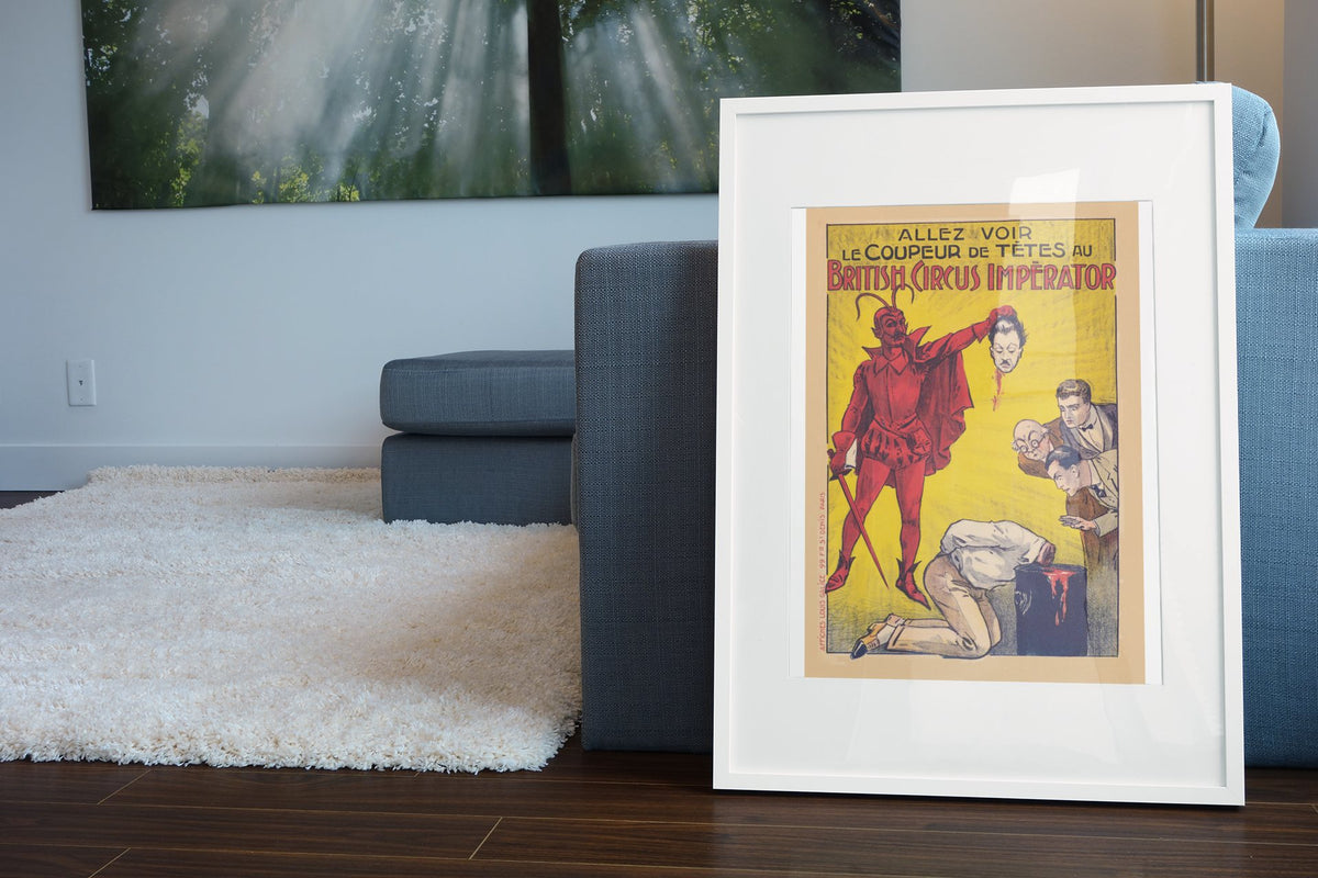 Le Coupeur de Tetes devil headsman poster leaning beside a blue sofa