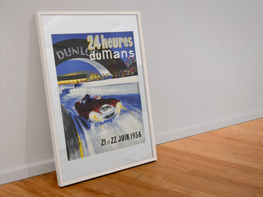 24 Heures du Mans 1958 poster in a white frame leaning against a wall