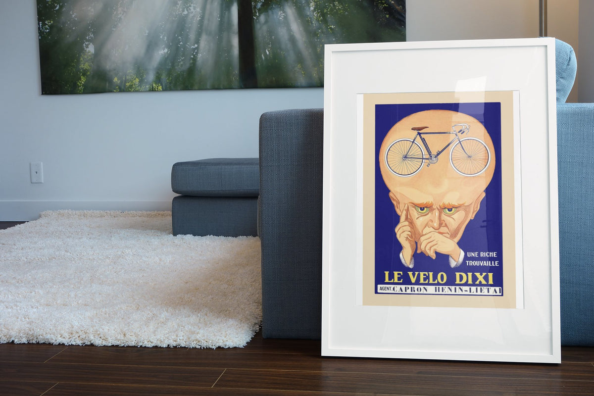 Le Velo Dixi poster leaning beside a blue sofa