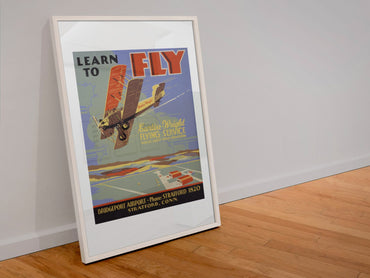 Learn to Fly Curtiss Wright poster in a white frame leaning against a wall