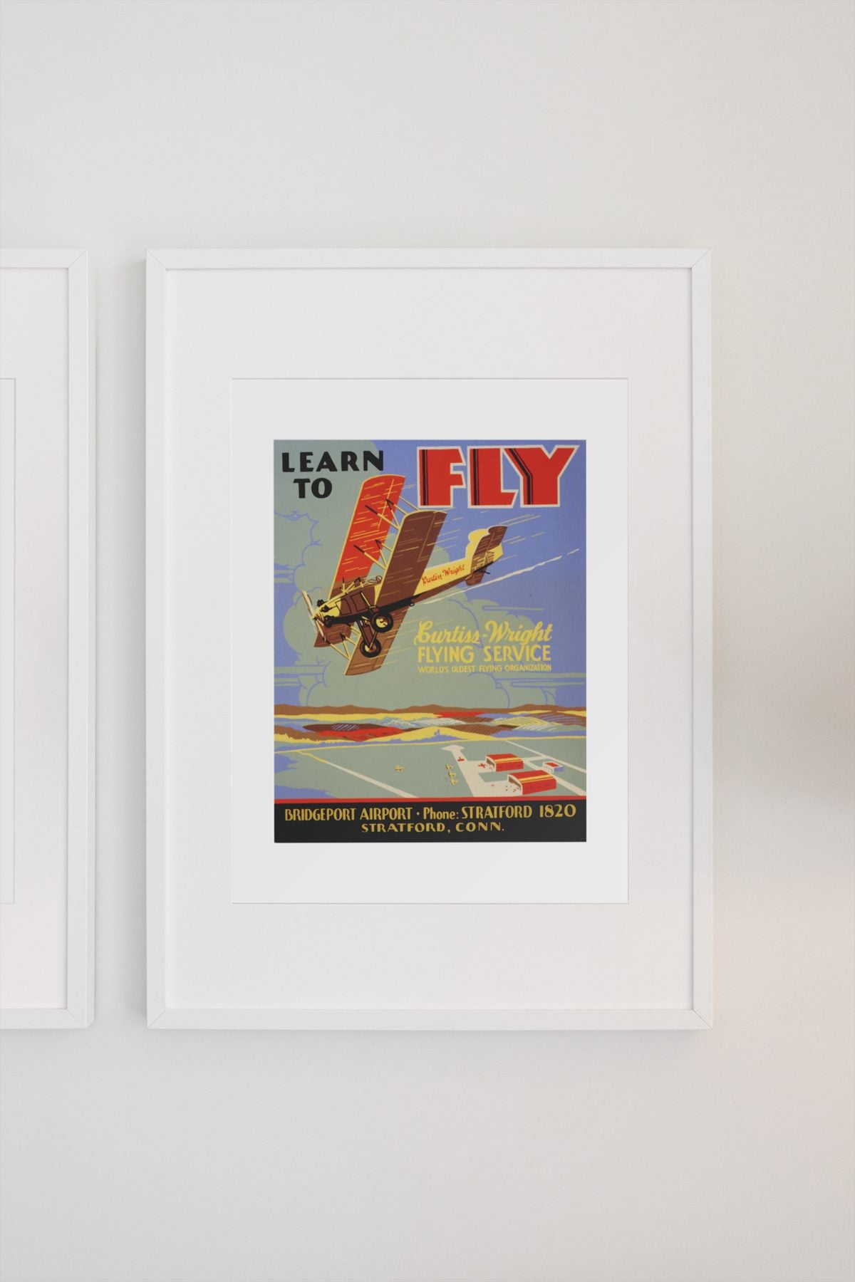 Learn to Fly Curtiss Wright poster on a light wall