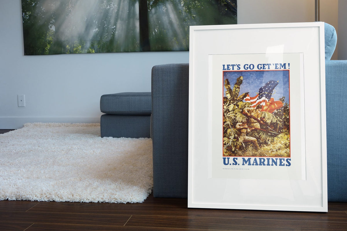 Lets Go Get Em US Marines poster leaning beside a blue sofa