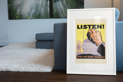 Listen poster in a white frame leaning beside a blue sofa