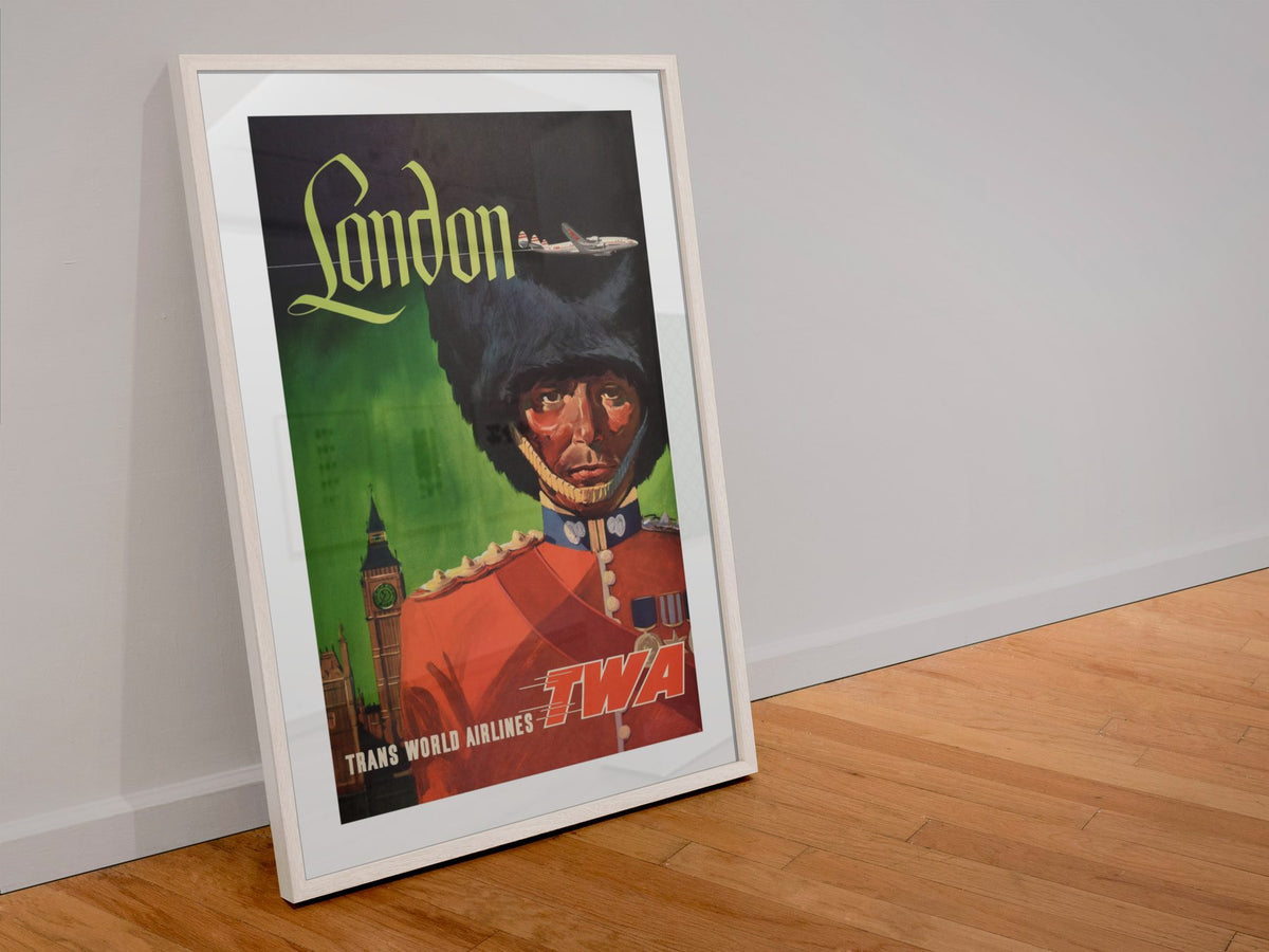 London Fly TWA Royal Guard poster in a white frame leaning against a wall
