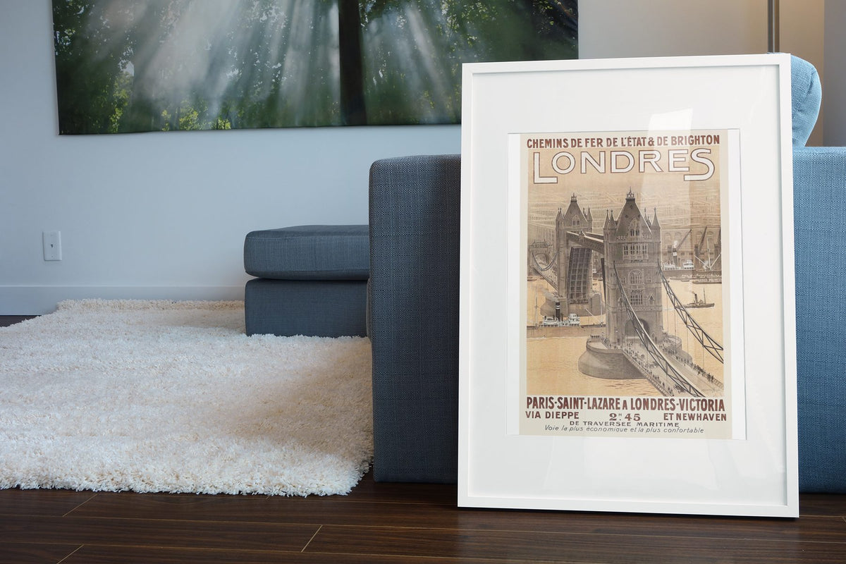 Londres Paris to London poster leaning beside a blue sofa