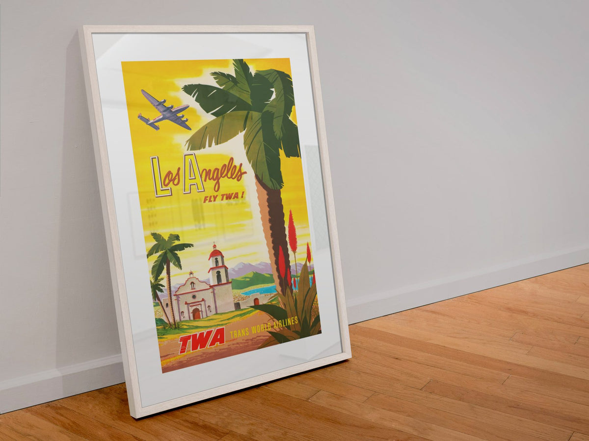 Los Angeles Fly TWA poster in a white frame leaning against a wall