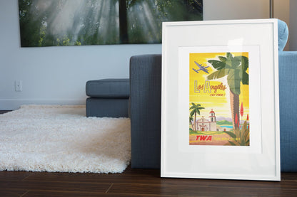Los Angeles Fly TWA poster leaning beside a blue sofa