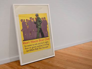 Many Heads Beat One poster in a white frame leaning against a wall