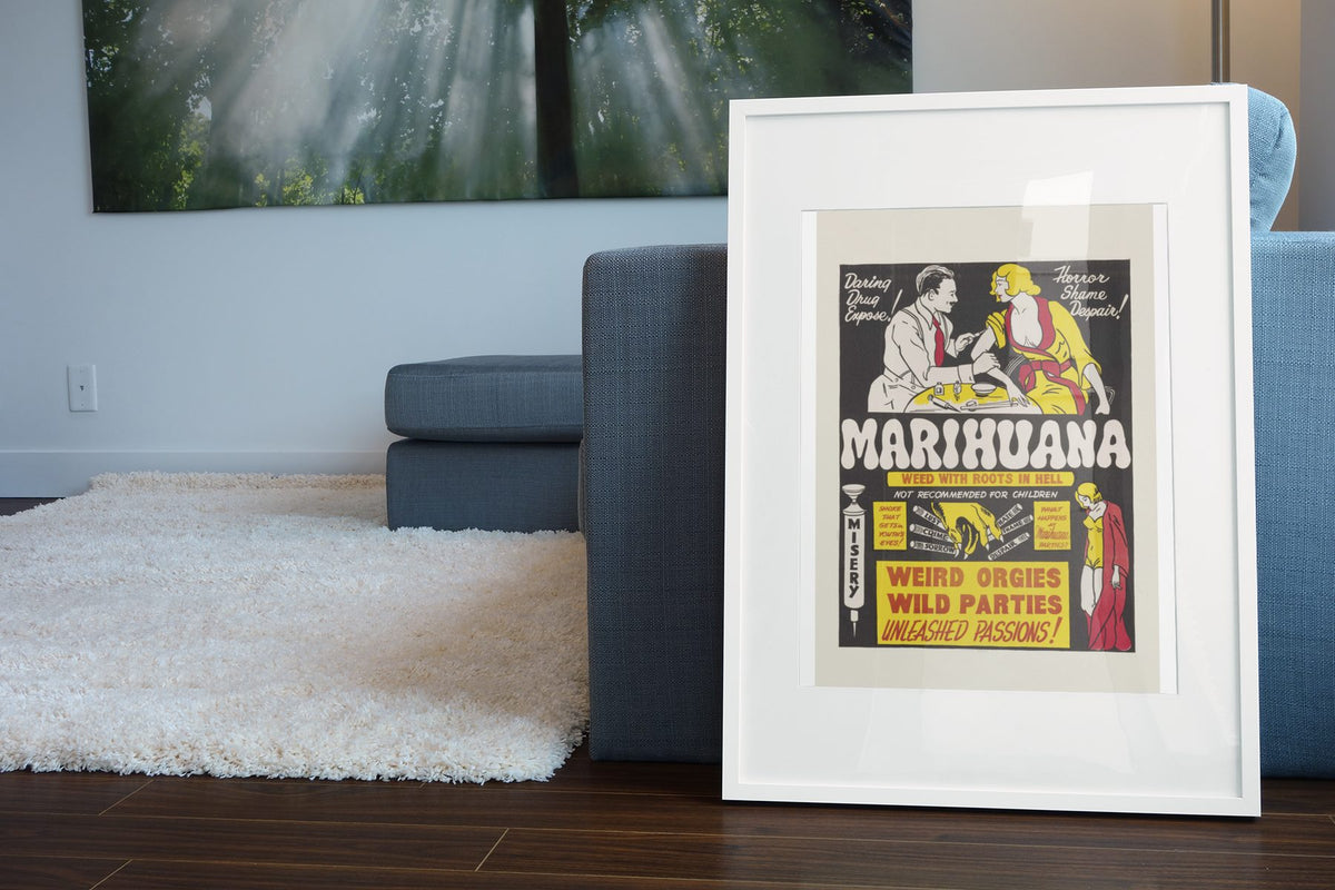 Marihuana Weed With Roots in Hell poster leaning beside a blue sofa