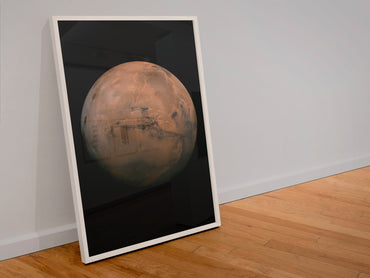 Mars with Valles Marineris poster in a white frame leaning against a wall