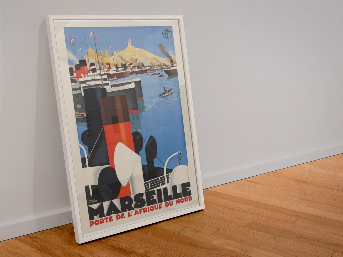 Marseille Porte de l Afrique du Nord poster in a white frame leaning against a wall