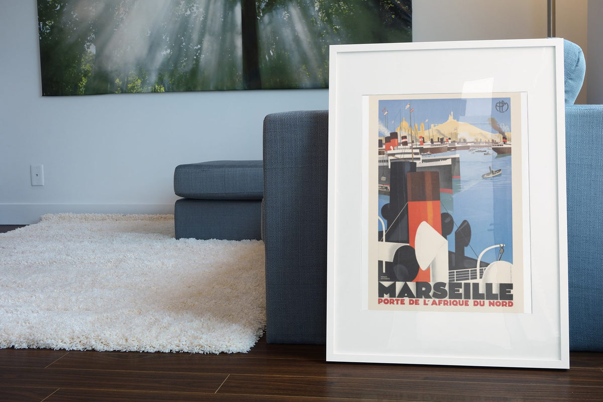 Marseille Porte de l Afrique du Nord poster leaning beside a blue sofa