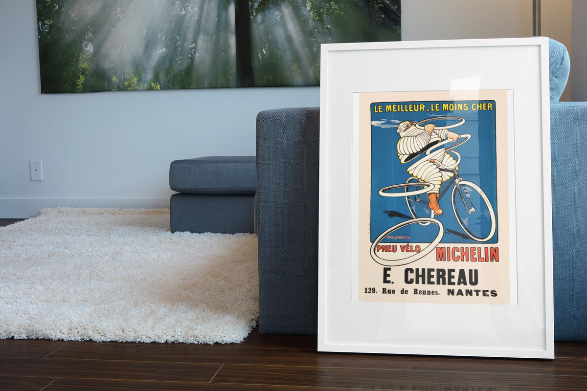 Michelin Pneu Velo Chereau poster leaning beside a blue sofa
