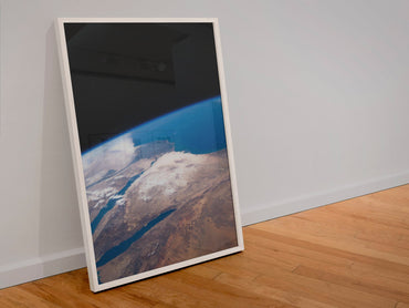 The Middle East seen from space poster in a white frame leaning against a wall