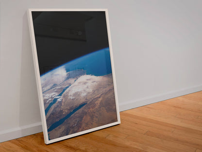 The Middle East seen from space poster in a white frame leaning against a wall