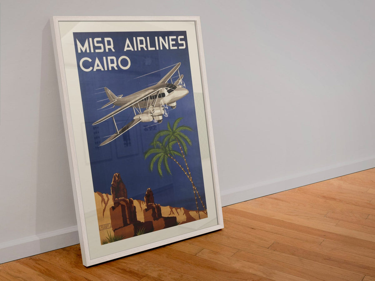 Misr Airlines Cairo poster in a white frame leaning against a wall