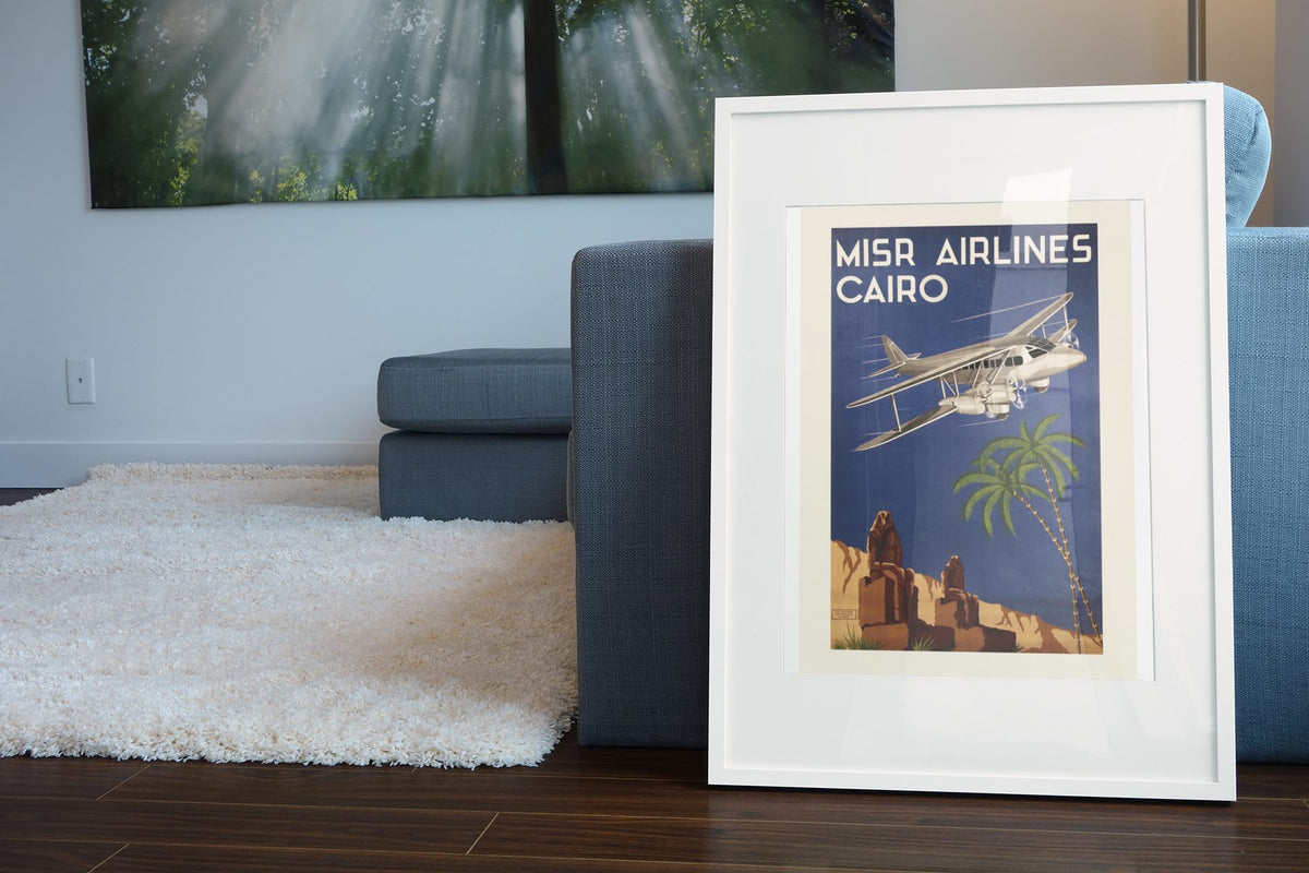Misr Airlines Cairo poster leaning beside a blue sofa
