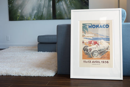 Monaco Grand Prix 1936 poster in a white frame leaning beside a blue sofa