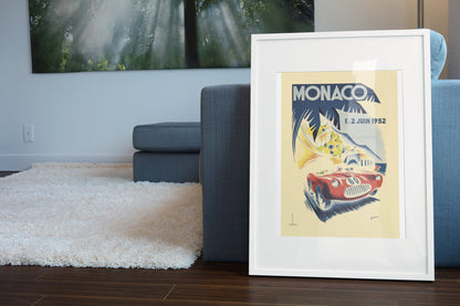 Monaco Grand Prix 1952 poster in a white frame leaning beside a blue sofa