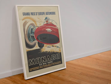 Monaco Grand Prix 1955 poster in a white frame leaning against a wall