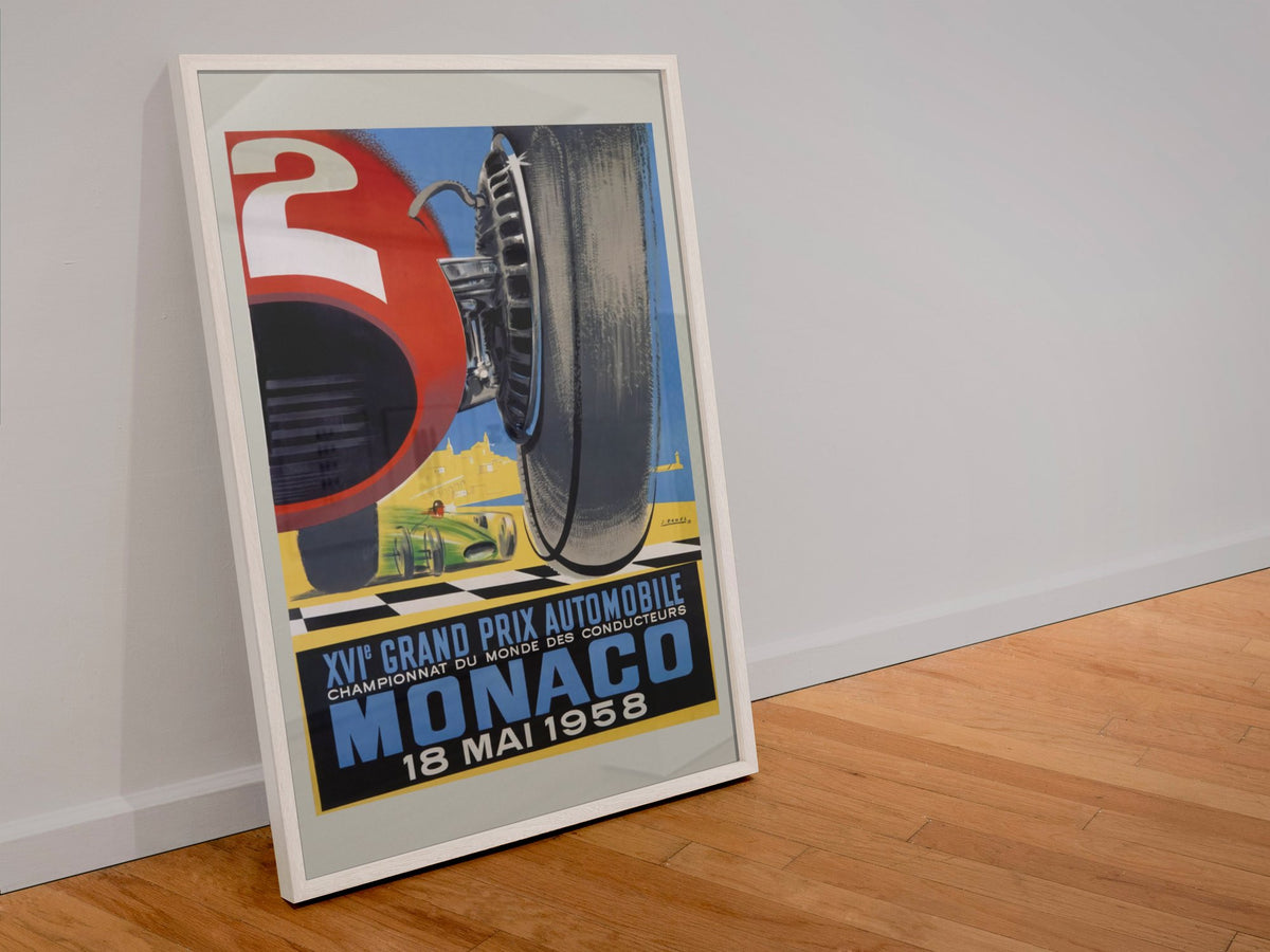 Monaco Grand Prix 1958 poster in a white frame leaning against a wall