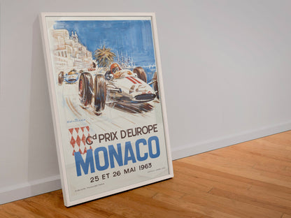 Monaco Grand Prix 1963 poster in a white frame leaning against a wall