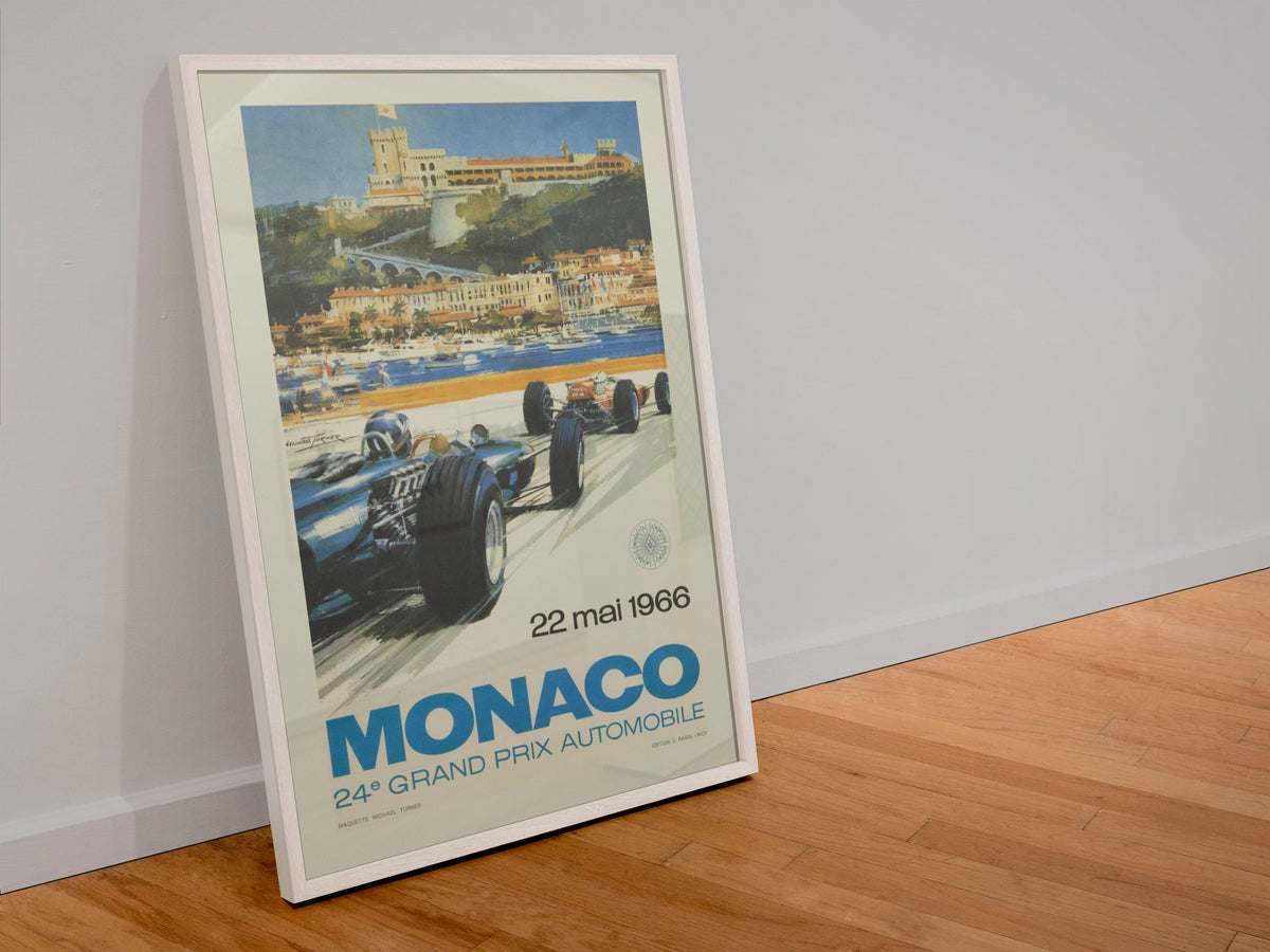 Monaco Grand Prix 1966 poster in a white frame leaning against a wall