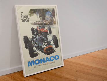 Monaco Grand Prix 1967 poster in a white frame leaning against a wall
