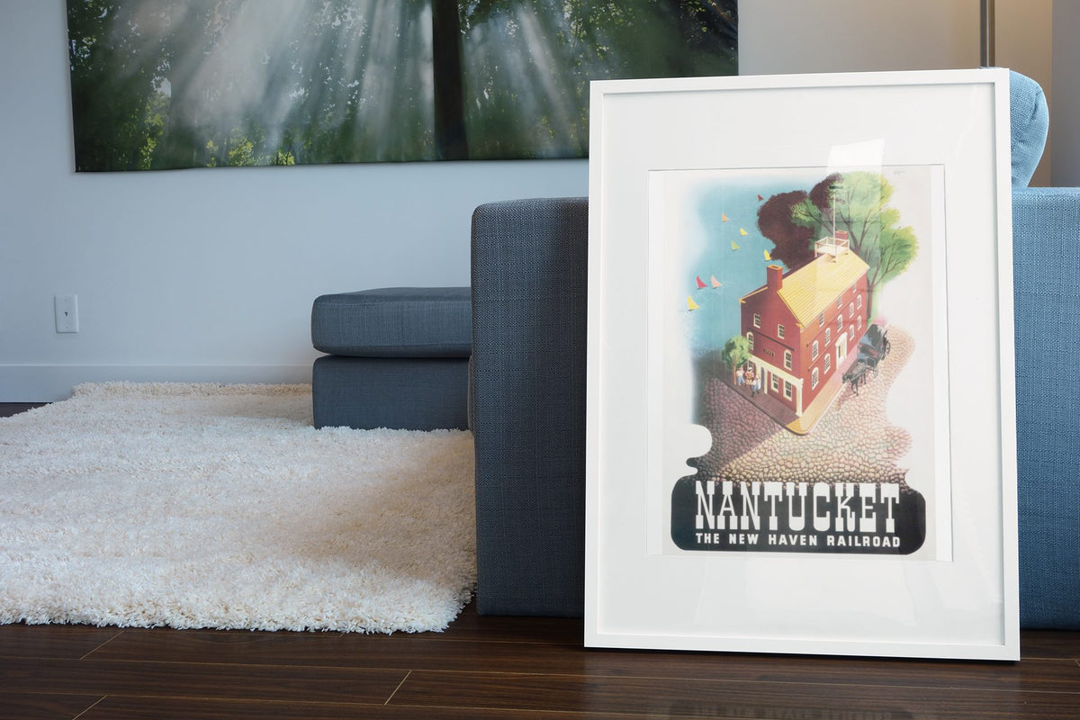 Nantucket New Haven Railroad poster leaning beside a blue sofa