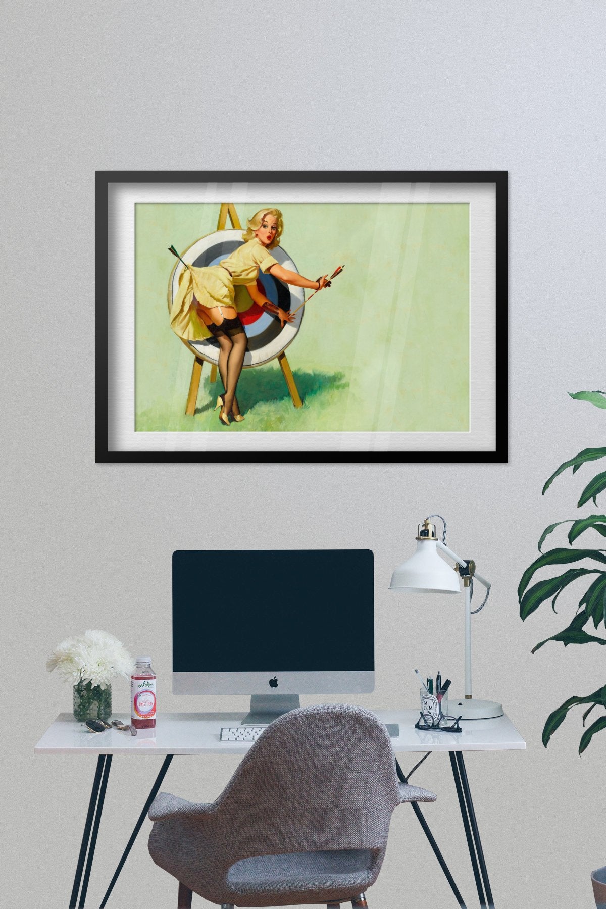 Near Miss by Gil Elvgren, pin-up poster — framed on desk