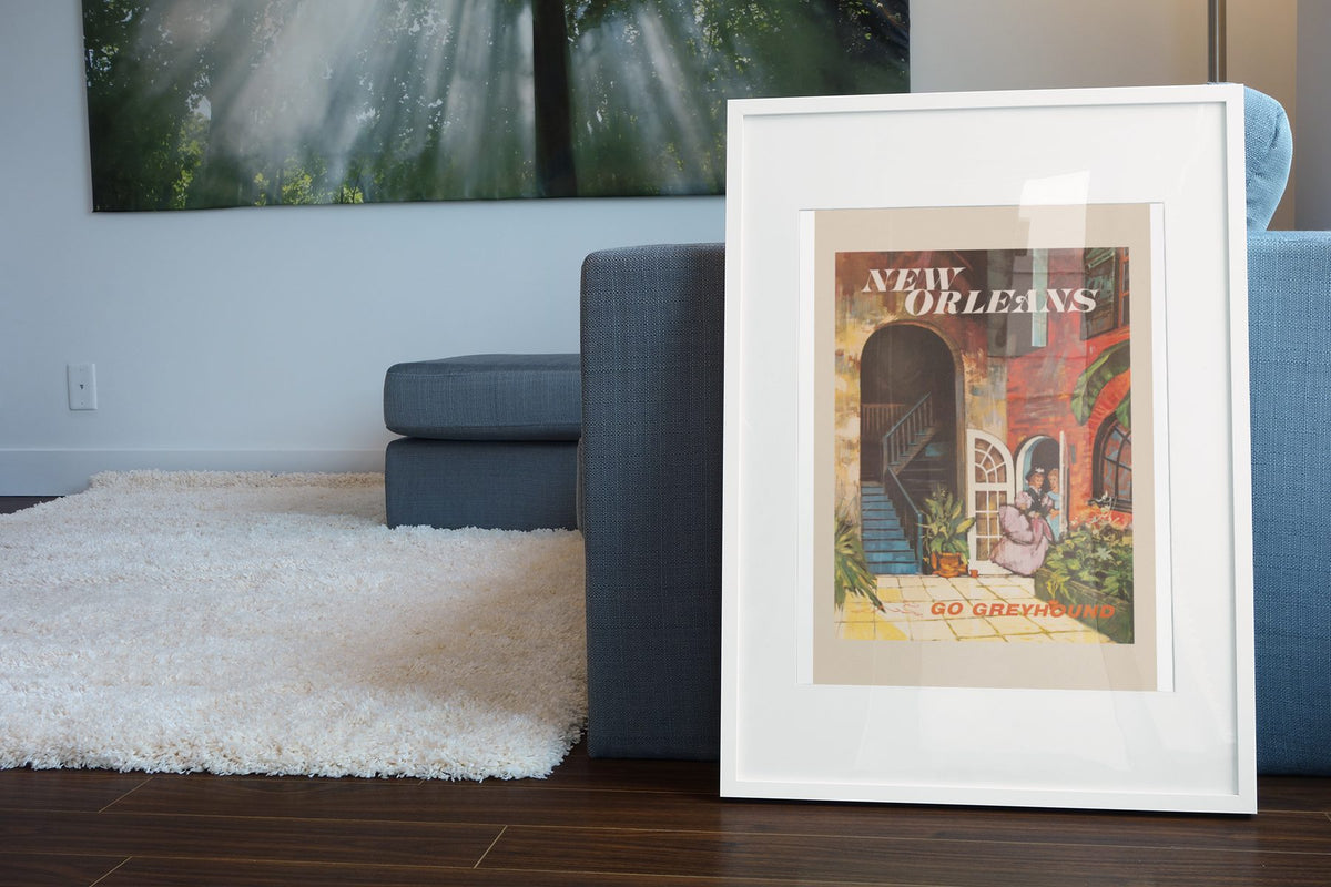New Orleans Go Greyhound poster leaning beside a blue sofa