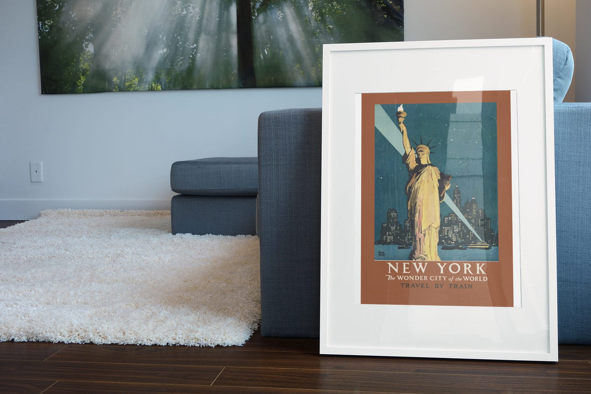 New York Wonder City Travel by Train poster leaning beside a blue sofa