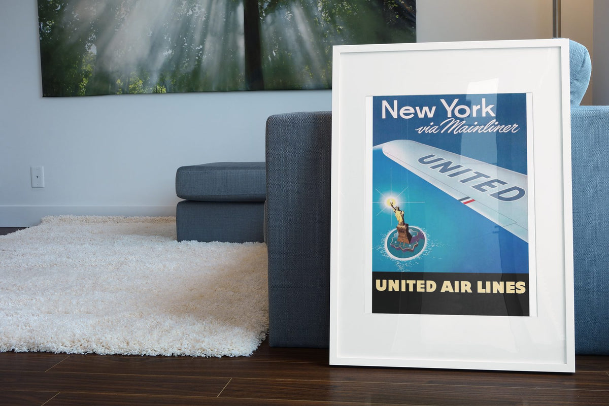 New York via Mainliner poster leaning beside a blue sofa