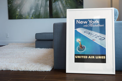 New York via Mainliner poster leaning beside a blue sofa