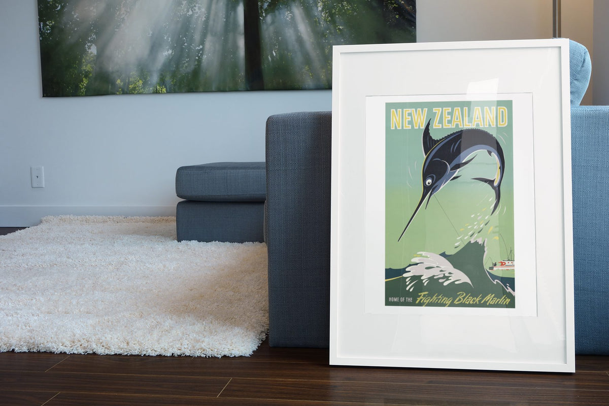 New Zealand Black Marlin poster leaning beside a blue sofa