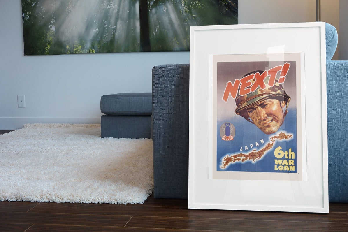 Next! Japan — 6th War Loan poster leaning beside a blue sofa