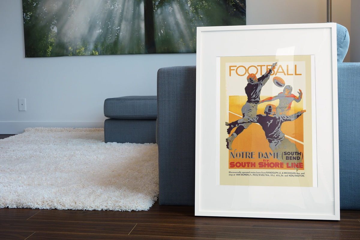 Notre Dame Football South Shore Line poster leaning beside a blue sofa