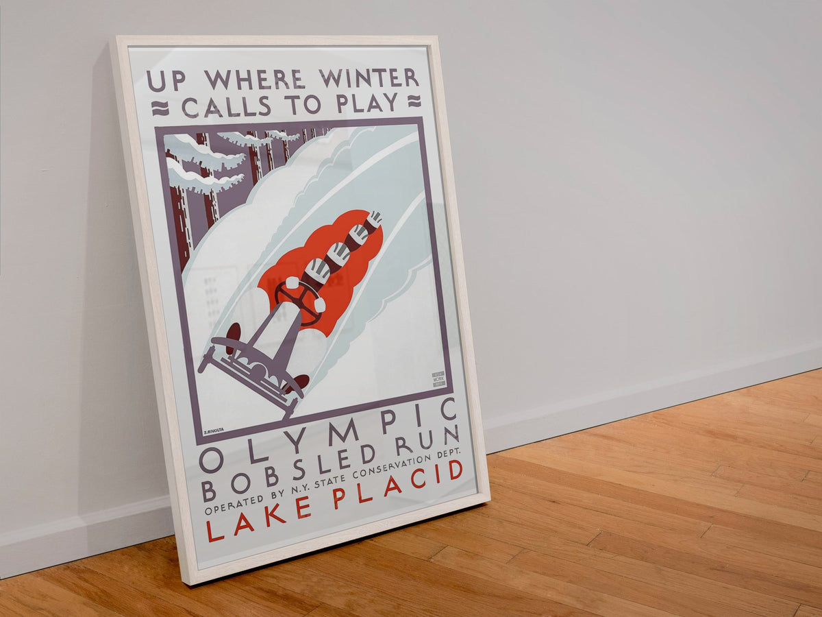 Olympic Bobsled Run Lake Placid poster in a white frame leaning against a wall