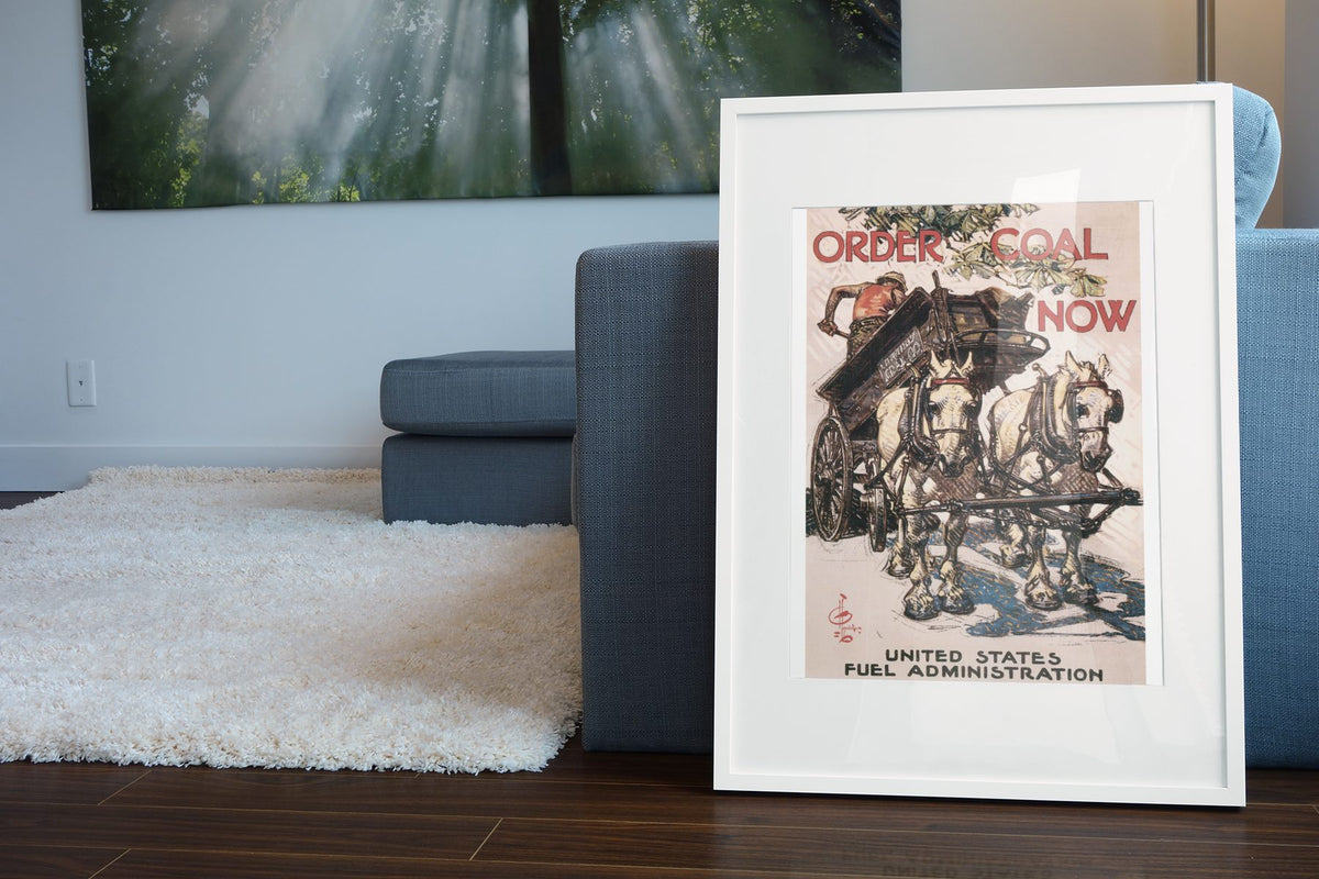 Order Coal Now poster leaning beside a blue sofa