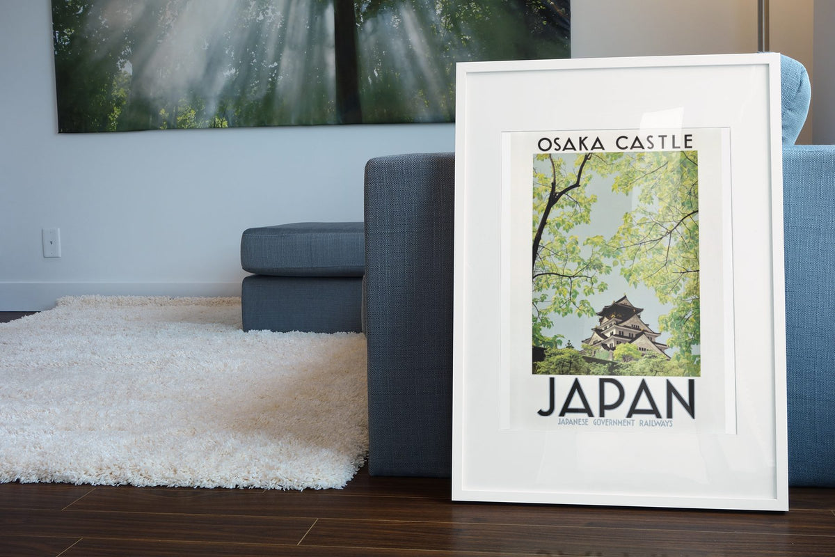 Osaka Castle Japan poster leaning beside a blue sofa