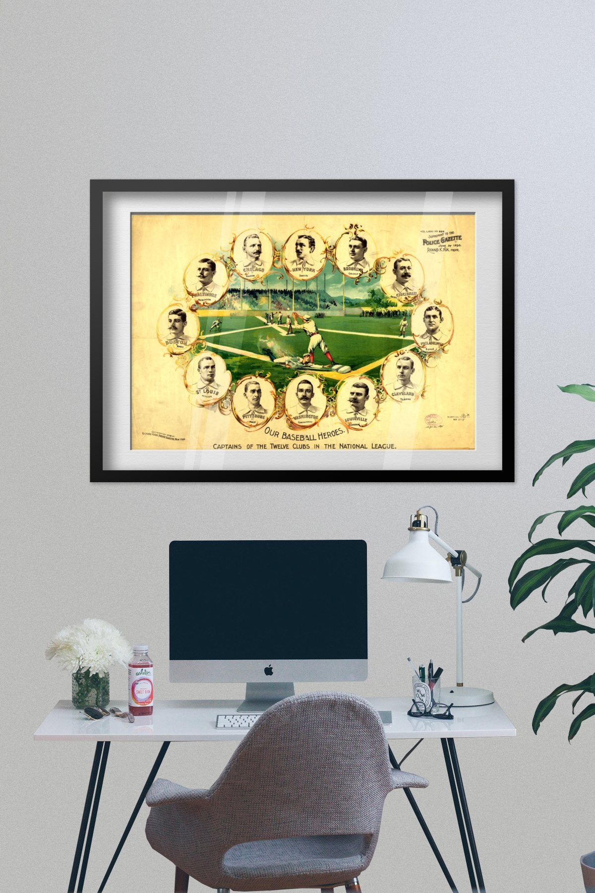 Our Baseball Heroes 1890s poster framed on a grey wall above a desk