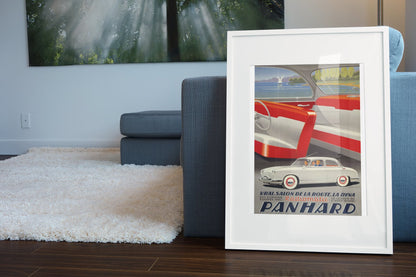 Panhard Dyna Radiomatic poster in a white frame leaning beside a blue sofa