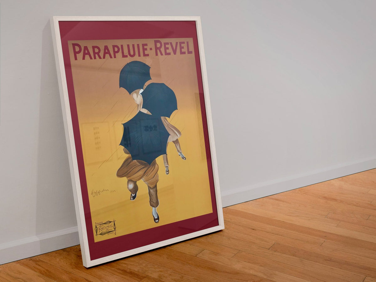 Parapluie Revel Cappiello poster in a white frame leaning against a wall